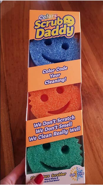 Smily face round sponges in green, orange, and blue 