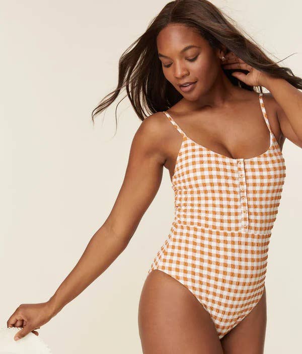 model wearing the orange gingham one-piece suit