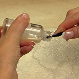 The Every Drop beauty spatula removing product from a bottle