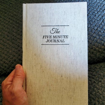 Reviewer holding cream journal that reads 