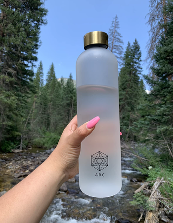 transparent white water bottle with gold twist lid 