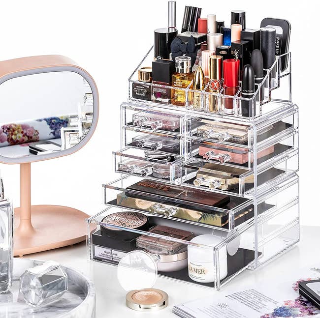 the acrylic makeup organizer full of products on a desk