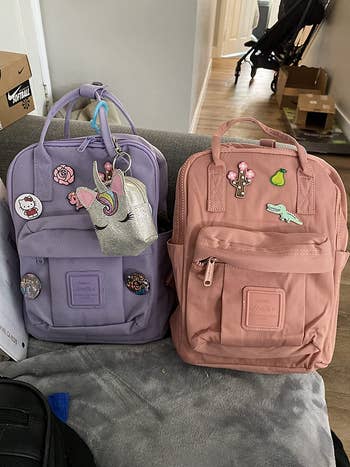 reviewer photo of purple and pink mini backpacks on sofa