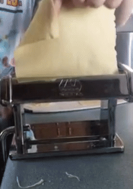 gif of reviewer feeding a sheet of pasta dough through the machine and it coming out sliced into noodles at the other end