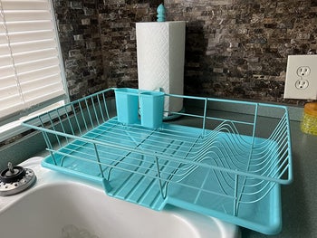reviewer photo of aquamarine plastic dish rack by a sink