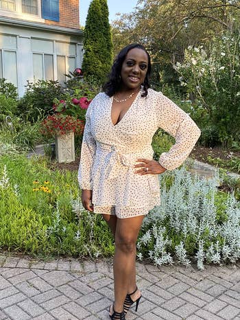 reviewer in long sleeve white romper with dot detailing and black heels