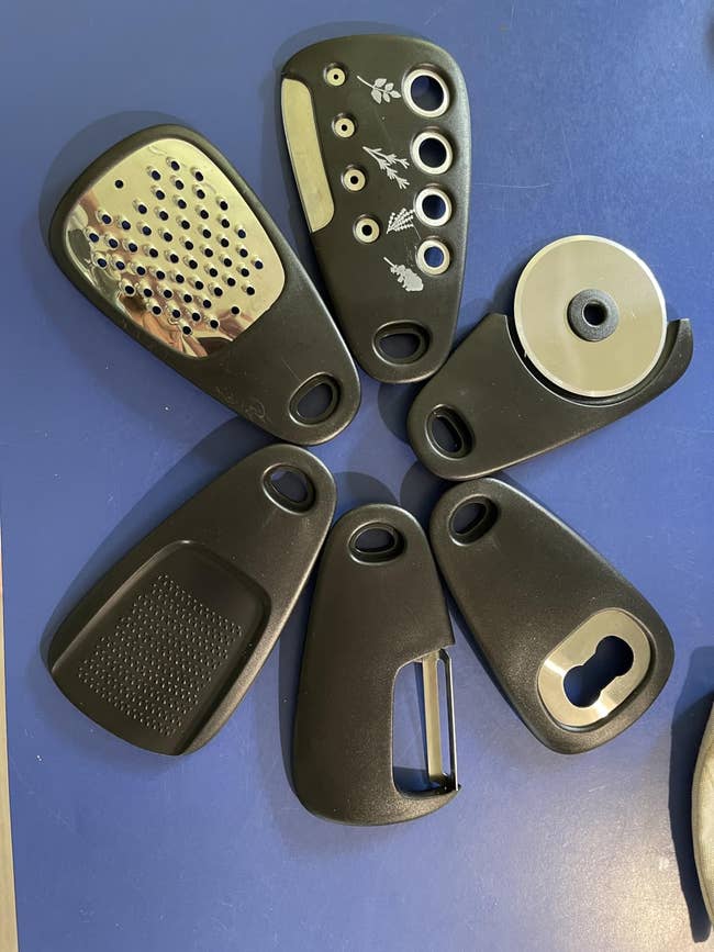 Set of six achromatic room tools including a grater, a slicer, and a vessel opener, arranged connected a table