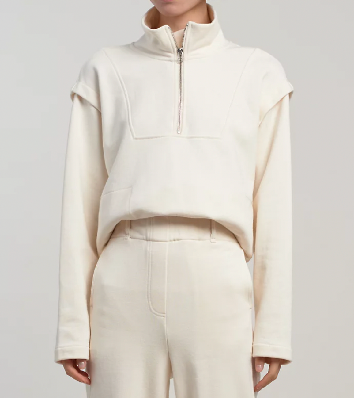 a model wearing the half zip up sweater in ivory