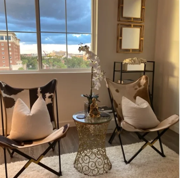 reviewer photo of two of the cowhide chairs in a bedroom