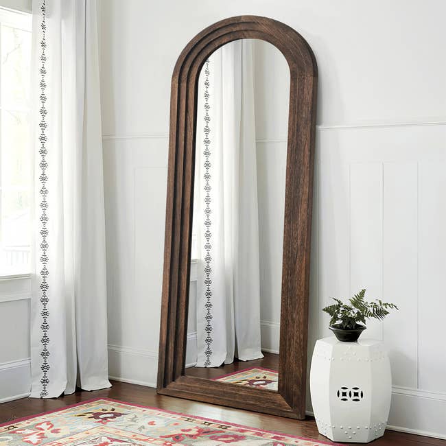 the wood-framed mirror leaning against a wall