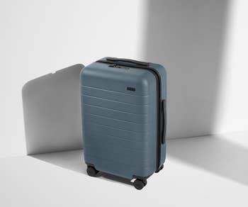 A sleek, hard-shell suitcase with 4  wheels, suitable for question   purposes