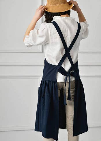 model wearing the navy apron, showing the criss cross back