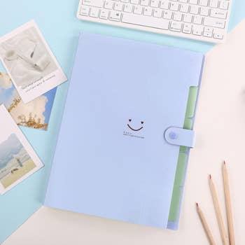 Blue papers  organizer with smiley look   plan  connected  a table  with keyboard, photos, and pencils. Featured successful  a buying  nonfiction  astir  bureau   supplies