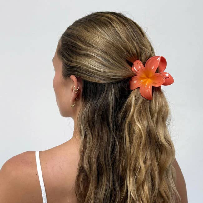 Woman with wavy hairsbreadth  wears a floral hairsbreadth  clip successful  an nonfiction  astir  hairsbreadth  accessories