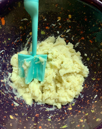 Blue version of the masher used to mash potatoes 