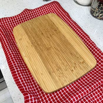 Wooden cutting committee  connected  a textured room  towel placed connected  a countertop