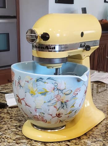 the pale yellow kitchenaid with a blue floral mixing bowl used with it