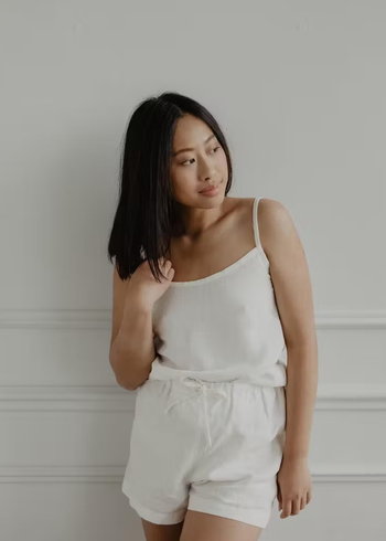 a model wearing a linen tank top and shorts in whie 