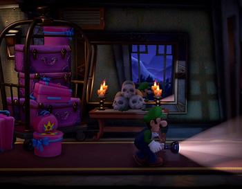 screenshot showing luigi walking down a dark hallway in luigi's mansion 3
