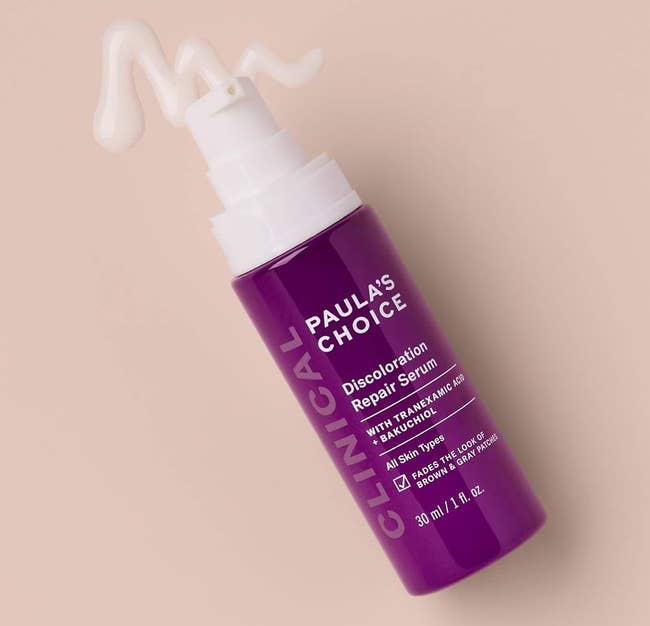 Purple bottle of Paula's Choice Discoloration Repair Serum with pump dispenser on a soft background