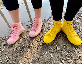 two reviewers wearing high-top sneaker style rain shoes in light pink and yellow