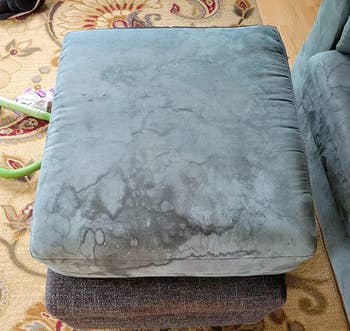 reviewer showing how dirty their sofa cushion is before using the cleaner