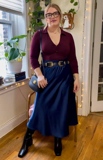 reviewer wearing navy version styled with long sleeve top belt and boots