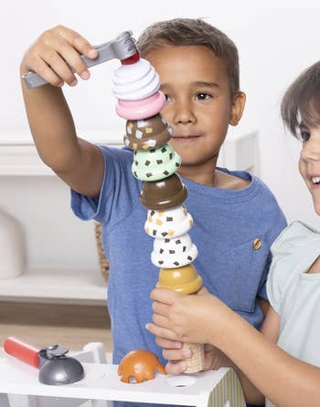 Two children happily stack colorful artifact  crystal  pick  scoops connected  a cone, demonstrating a fun, originative  play   activity