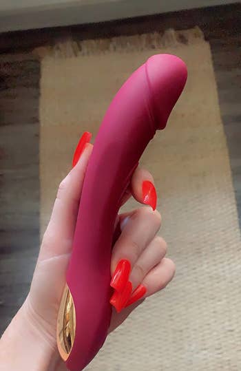 Hand holding realistic red vibrator