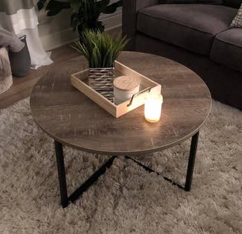 Reviewer image of the brown round coffee table with a candle