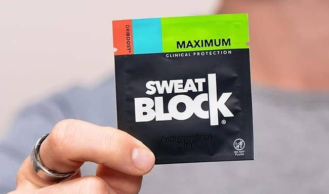 hand holding a bundle of Sweat Block wipes