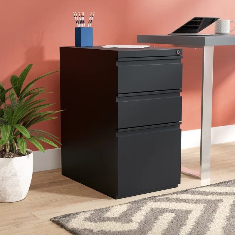 a black filing cabinet next to a desk