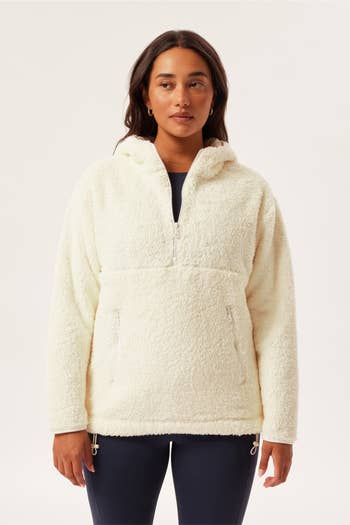 model wearing the white fleece hoodie