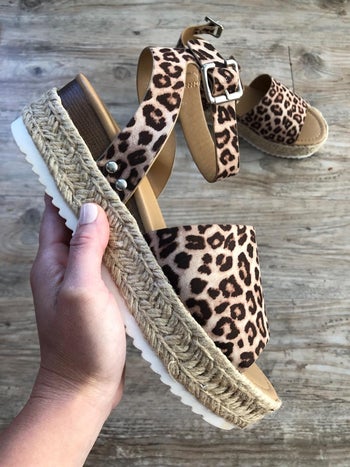 reviewer holding the cheetah print platform sandal