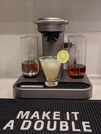 reviewer's machine set up with margarita glass underneath and a bar mat that says 