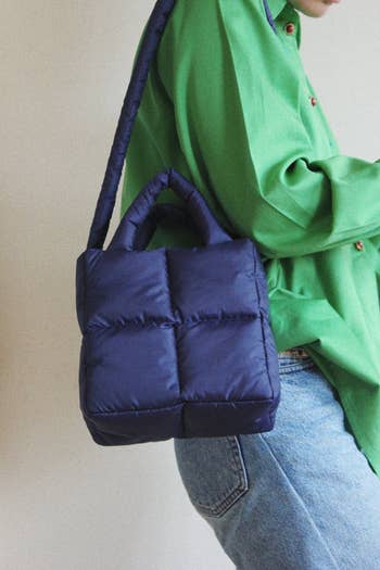 a model wearing the mini pillow puffer bag in navy