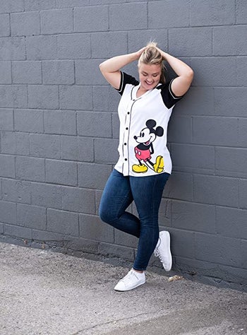 a model in a button down black and white mickey baseball jersey