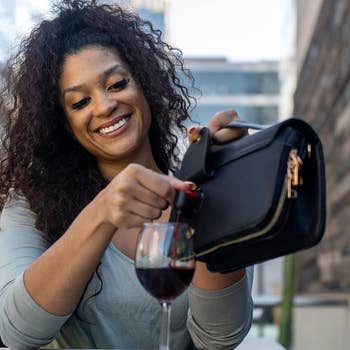 a model pouring wine into a glass from the smaller bag
