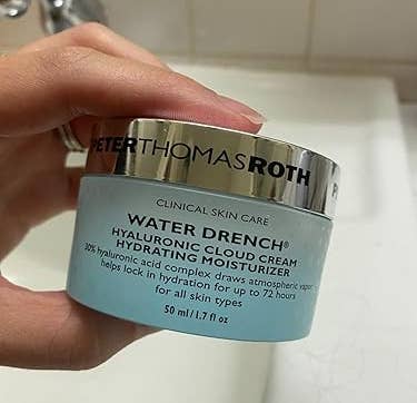 Hand holding Peter Thomas Roth Water Drench Hyaluronic Cloud Cream, a moisturizer that hydrates tegument for up to 72 hours
