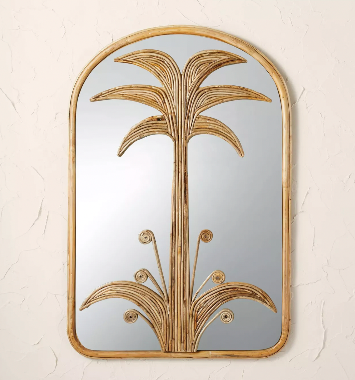 a rattan palm mirror on a wall