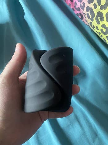 reviewer holding black vibrating sleeve