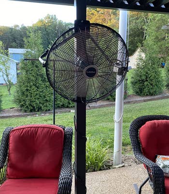 reviewer photo of the fan hung up on a post on a back deck