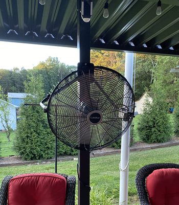 reviewer photo of the fan hung up on a post on a back deck