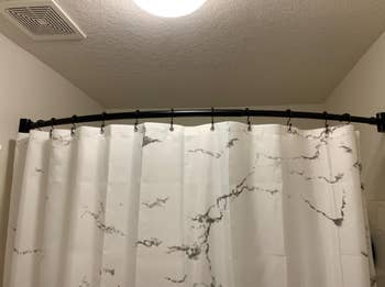 reviewer pic of bathroom with curved shower curtain rod