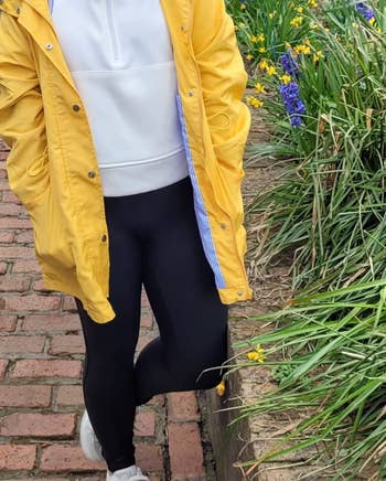 reviewer wearing the white pullover underneath a yellow raincoat
