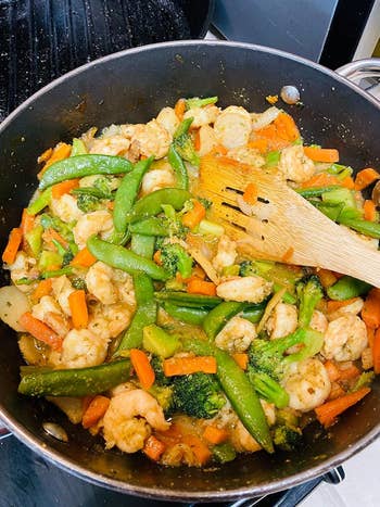 Stir-fry dish with shrimp and mixed vegetables being cooked in a pan