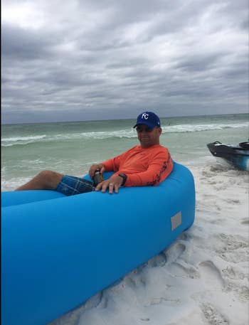 Reviewer hanging out in blue blown up lounger on the beach 