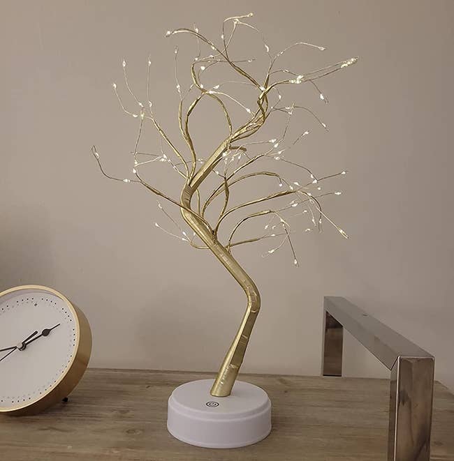 reviewer photo of the gold bonsai lamp on a table