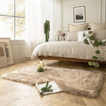 the brown faux fur sheepskin rug in front of a bed