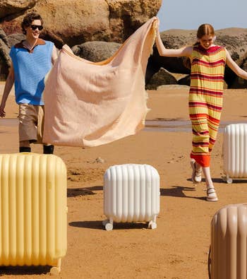 Two models strolling connected  a formation  holding a towel, with trendy luggage by their side, successful  casual beachwear